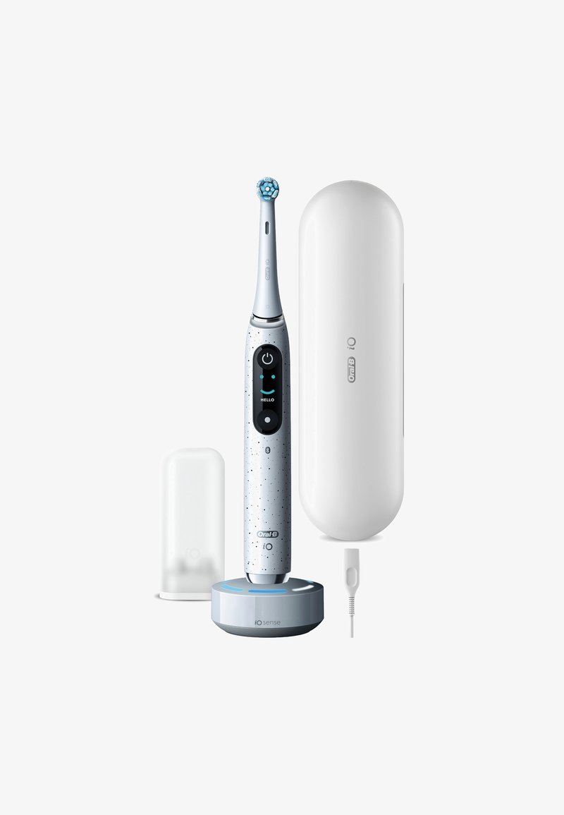 Brosse à dents électrique avec un manche bleu clair, un écran noir et une base de chargement blanche. Comprend un étui de voyage protecteur et un câble de chargement.