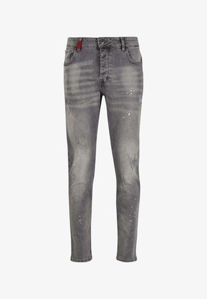 Grå denim jeans med slim fit, der har slidte detaljer, lette folder, malingstænk og en rød detalje på taljebåndet.
