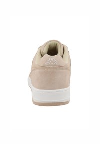 Baskets en daim beige clair avec une semelle en caoutchouc blanc, dotées d'un col rembourré et d'une semelle extérieure texturée, agrémentées d'un logo blanc à l'arrière.
