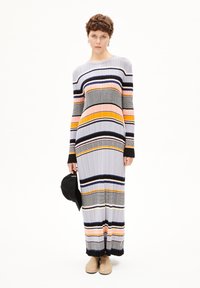 Lång, ribbads klänning med flerfärgade horisontella ränder i grått, orange och svart. Har långa ärmar och en rund halsringning.