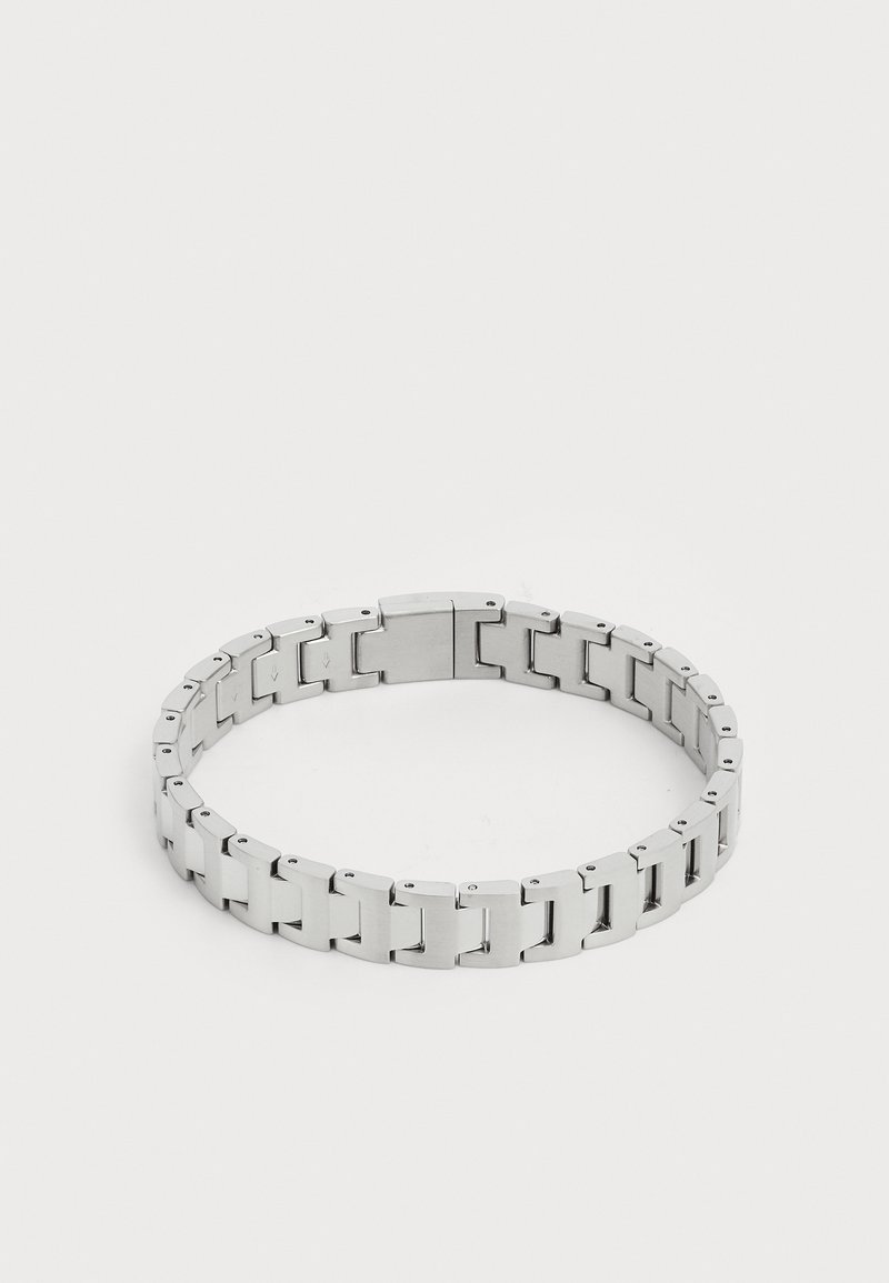 Srebrna kovinska zapestnica z medsebnimi povezavami, ki se ponaša z gladko, polirano površino in varnim zaponkom za enostavno nošenje.