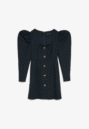 Tumesinine polka dot mustriga kleit, millel on õhukesed varrukad, ruudukujuline kaelus ja kuldsed mesilase-kujulised nööbid. Pehme kangas, põlvepikkune, seljal lukuga.