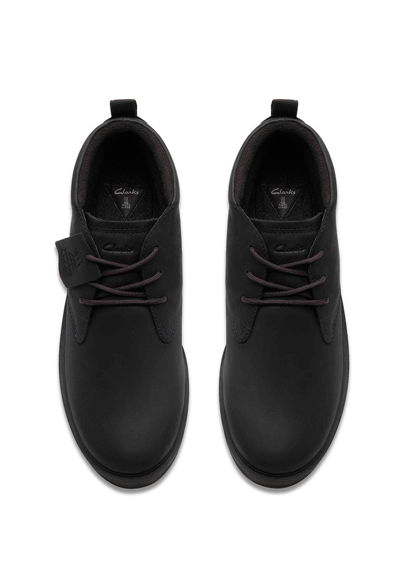 Schwarze Lederschuhe mit glatter Oberfläche, Schnürdesign und einem kleinen Logotag an der Seite. Gepolstertes Innenfutter für Komfort.