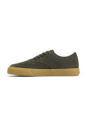 Zapatillas de ante verde oliva con suela de goma color tostado, puntera redonda, cierre de cordones y diseño minimalista. Textura suave y costuras sutiles.
