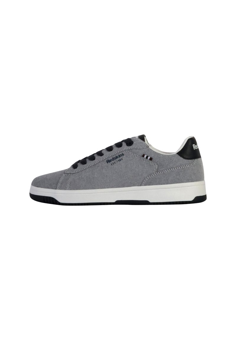 Zapatillas deportivas de lona gris con detalles en negro, suela blanca y diseño con cordones. Presenta un logo y detalles de costura en el costado.