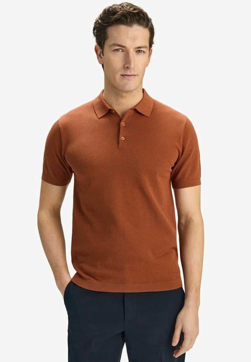 Kortärmad polo i bränd orange, med ett texturerat mönster, treknappsknäppning och ribbad krage och fåll.