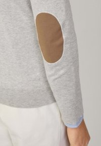 Helles graues Sweatshirt mit tailliertem Design. Braune Ellbogenpatch-Details, gerippte Bündchen und gestreifter Saum der inneren Ärmel sichtbar. Weicher Stoff.