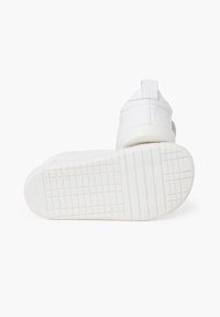 Weiße Sneaker mit einer strukturierten Gummisohle, glattem Obermaterial und verstärktem Absatz. Verfügt über einen Riemen an der Rückseite für ein einfaches Anziehen.