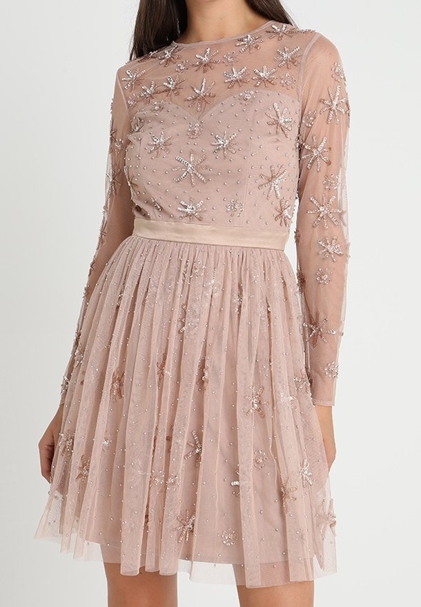Robe en maille perlée dans un doux rose poudré, avec des manches longues, un corsage ajusté, une jupe évasée et des broderies florales avec des accents scintillants.