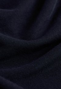 Tengerészkék szövet finom, texturált szövettel, sima felülettel és lágy eséssel, kiemelve a varrás részleteit és a színmélységet.