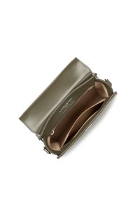 Una borsa a tracolla in pelle verde aperta che mostra un interno beige, con due scomparti e un'etichetta del marchio all'interno.