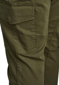 Olīvu zaļas kravu bikses, kas izgatavotas no izturīga auduma, ar sānu kabatu un pastiprinātām šuvēm izturībai.