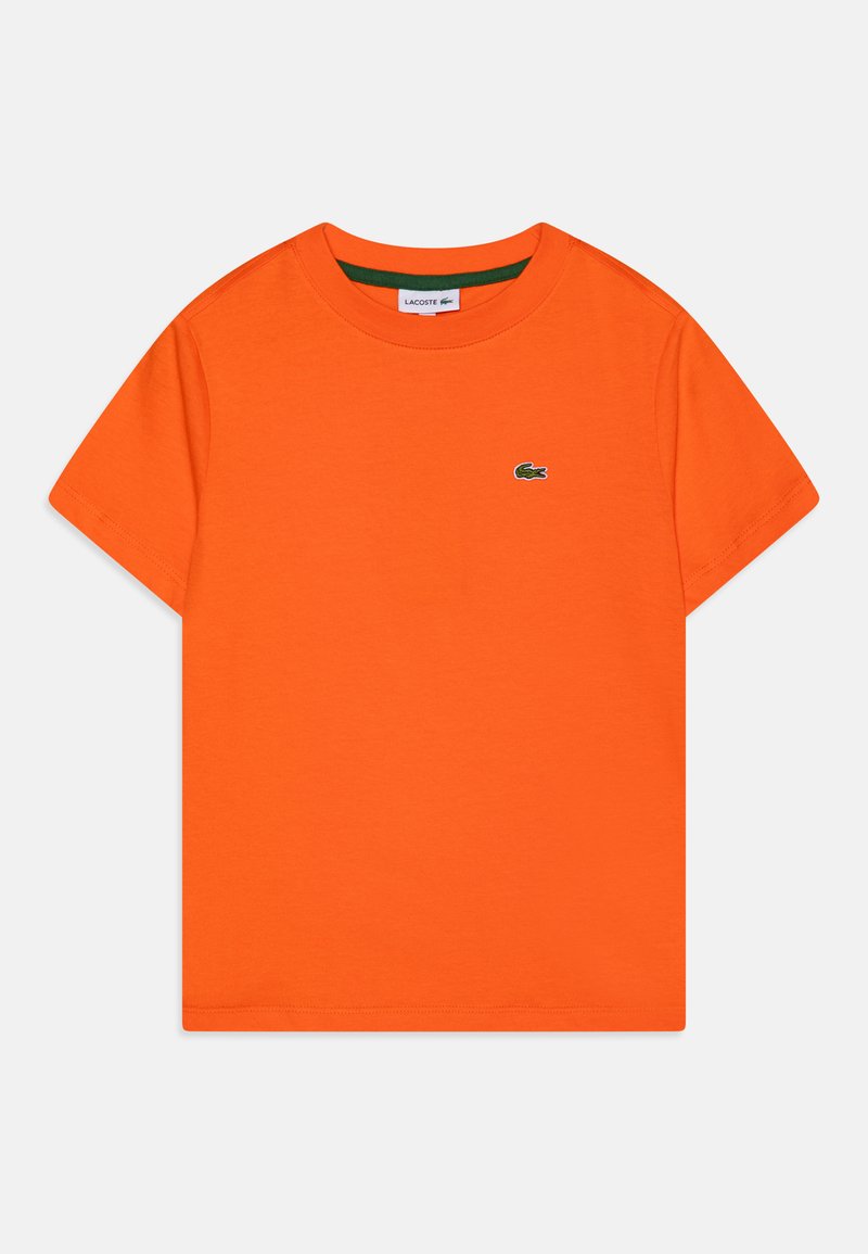 Kortsleevede oransje T-skjorte laget av bomull, med en liten grønn brodert krokodillelogo på brystet og rund hals.