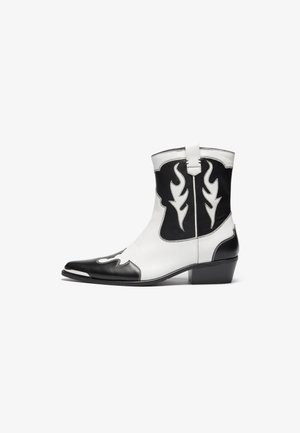 Black and white cowboy boots with flame patterns, pointed toe, and a short heel. Made of leather with contrasting stitching and pull tabs.