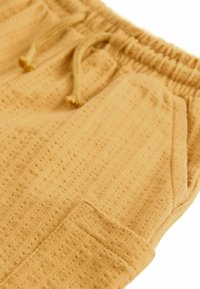 Next REGULAR FIT - Pantaloni sportivi - ochre yellow