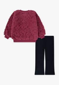 Bordo fleecová mikina s textúrovaným vzorom a rebrovanými manžetami, skombinovaná s čiernymi rebrovanými legínami. Obe položky sú mäkké a vo voľnom strihu.
