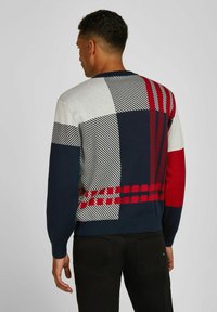 Strickpullover mit geometrischen Mustern in Marineblau, Rot, Grau und Weiß, mit unterschiedlichen Texturen und einem runden Halsausschnitt.