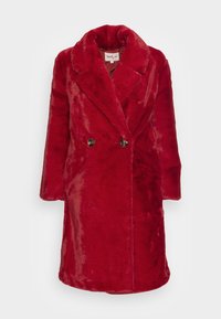 Pitkä punainen keinoturkistakki, jossa on kaksirivinen napitus, leveät kaulukset ja kaksi tummanväristä nappia, esillä valkoisella taustalla.