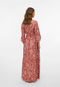 Maxi-jurk met een abstracte rode en crèmekleurige print, lange mouwen met ruches en een strikceintuur. Gemaakt van een lichtgewicht stof.