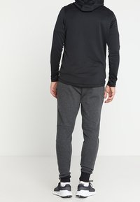 Under Armour Teplákové kalhoty - black