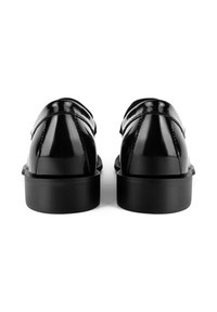 Black patent leather shoes with a rounded toe, smooth texture, minimal stitching, and a low, flat sole. Rear view showcasing clean lines.