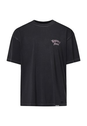 T-shirt nera a maniche corte con piccolo testo gotico rosa e bianco sul petto sinistro e una piccola etichetta vicino all'orlo inferiore.