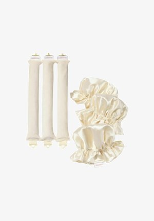 Drie beige fluwelen haarrollers met clips en drie crèmekleurige satijnen scrunchies gerangschikt op een witte achtergrond.