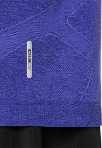 Purple athletic shirt with texture variations, featuring a logo label reading "ACTIBREEZE" and contrasting black elements below.