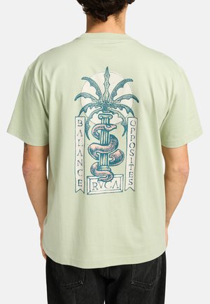 Mint green short-sleeve t-shirt featuring a graphic design on the back, including a snake and palm tree, with text: "BALANCE OPPOSITES RVCA."