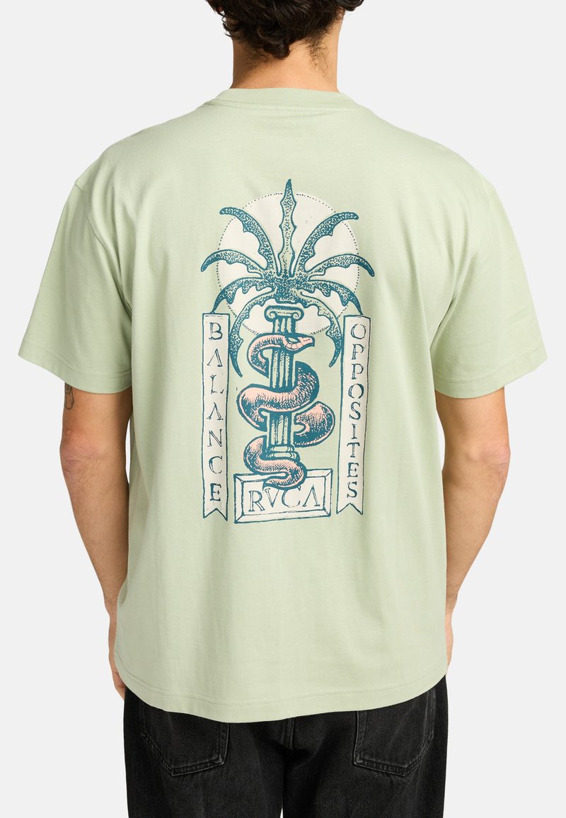 Camiseta de manga corta verde menta con un diseño gráfico en la parte posterior, que incluye una serpiente y una palmera, con el texto: "BALANCE OPPOSITES RVCA."