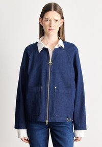 Τζιν μπουφάν σε σκούρο μπλε χρώμα· διαθέτει φερμουάρ στο μπροστινό μέρος, δύο μπροστινές τσέπες και επιχρυσωμένα μεταλλικά στοιχεία. Δομημένο σχήμα με γιακά.