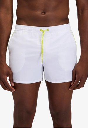 Torace maschile che indossa pantaloncini da bagno bianchi con coulisse giallo neon e dettagli sulle tasche laterali, in piedi su sfondo bianco.