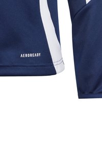 Camisa de desporto azul-marinho com detalhes brancos, feita de tecido respirável. Apresenta o logo "AEROREADY" perto da bainha. Superfície texturizada para gestão de humidade.