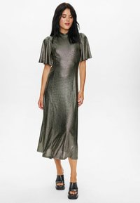 Metallic green midi dress with short flutter sleeves and a ribbed texture, paired with black platform sandals. Smooth, fitted silhouette.