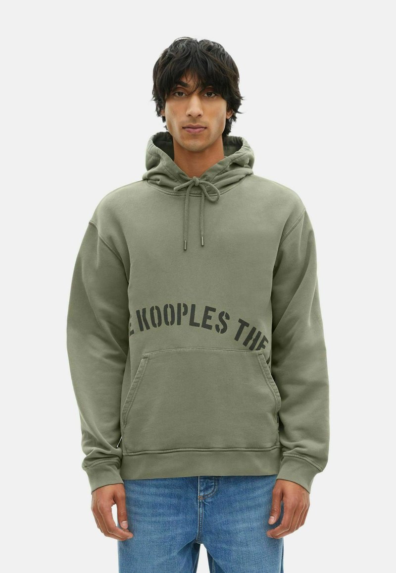 Hoodie vert olive avec cordon de serrage, poche frontale et texte noir en gras sur la poitrine. Tissu doux avec une coupe décontractée.