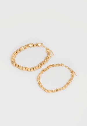 Kaks kuldsed helmestega käevõru ebaühtlaste ja tekstuuriga helmeste ja heledal taustal, kummaski väikese ketiga luku abil reguleeritav.