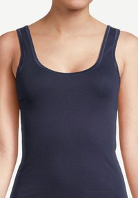 Navy blue tank top with a scoop neckline, thin straps, and a fitted design. Soft, stretchy fabric with smooth texture and minimal stitching.