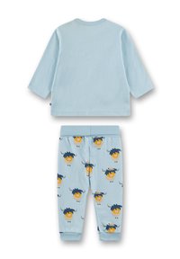 Hellblaues Baumwoll-Pyjama-Set mit langärmeligem Oberteil und Hose. Die Hose ist mit cartoonhaften Tieren in Gelb und Dunkelblau auf einem blauen Hintergrund verziert.