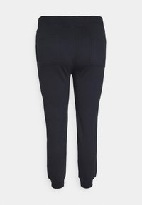 Černé tepláky s elastickým pasem, dvěma zadními kapsami a manžetami na kotnících. Vyrobené z m ěkké, hladké tkaniny s klasickým střihem.