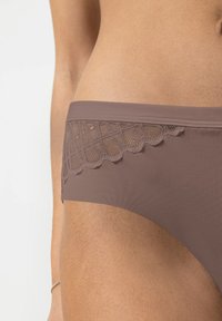 Brown bikini bottom with a textured lace panel on the side, featuring a scalloped edge and smooth fabric.