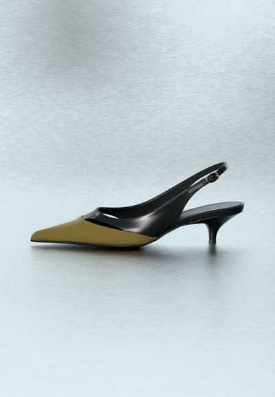 Czółenka typu slingback z ostrym noskiem, oliwkowo-zieloną przednią częścią i czarną skórzaną cholewką, z niskim obcasem kocim i regulowaną klamrą paska.