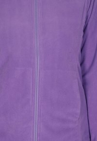 Lila fleece zip-up jacka med en jämn textur, lättviktig design och en central dragkedja. Inga ytterligare mönster eller accenter.