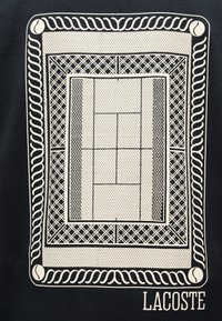 Σχεδίαση γηπέδου τένις με στυλ, περιτριγυρισμένη από ένα διακοσμητικό πλαίσιο με μπάλες τένις, το κείμενο "LACOSTE" από κάτω σε σκούρο φόντο.