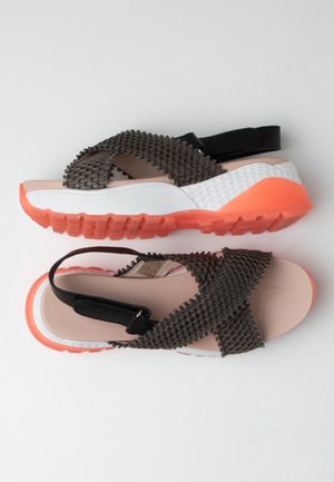 Sportliche Sandalen für Damen mit strukturierten schwarzen Riemen, gepolsterten rosa Fußbetten, weißen Zwischensohlen und dicken orangefarbenen profilierten Sohlen.