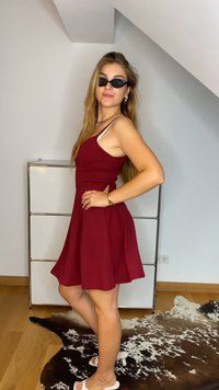 Bordo bešvarkis su prigludusia liemene ir platėjančia sijonu, dėvimas su juodais saulės akiniais. Lygus audinys ant medinio grindų paviršiaus ir raštuotos kiliminės dangos.