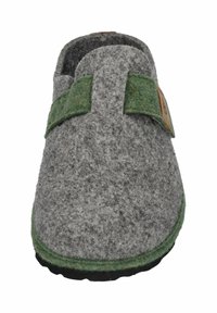 Zapatilla de casa gris de fieltro con una correa de fieltro verde y un detalle de cuero marrón. Forma redondeada con una superficie texturizada y suela negra.