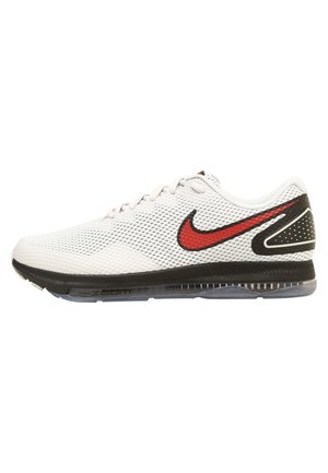 Chaussure de course Nike en mesh blanc avec logo swoosh noir et rouge, semelle noire et amorti transparent, vue de profil sur fond blanc.
