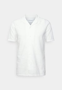 Chemise blanche à manches courtes avec boutons, col cranté et coupe décontractée, présentée sur un fond gris neutre.