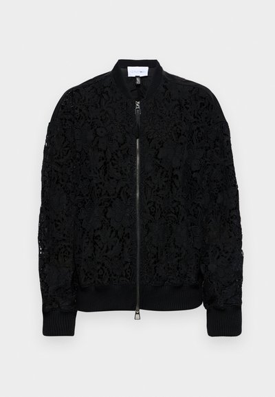 Must mustrakk, millel on keerukad lilleline pitsdisain, soonikkoes ja serv, ning hõbedane lukustus. Läbipaistvad osad paljastavad alusematerjali.