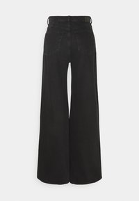 Jeans de mezclilla negra de pierna ancha con cintura alta, que cuentan con dos bolsillos traseros y un diseño minimalista. Fabricados con una tela resistente y texturizada.